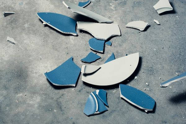 Zerbrochenes blaues Geschirr auf dem Boden